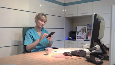Young receptionist browsing smartphone and drinking coffee. Stock Footage 70307000