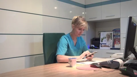 Young receptionist browsing smartphone. Stedaicam shot. Vidéo 70306897