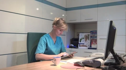 Young receptionist coping data from tablet to documents. Steadicam shot. 動画素材 70306925