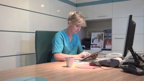 Young receptionist working on tablet at the desk. Steadicam shot. Vídeo Stock 70306805
