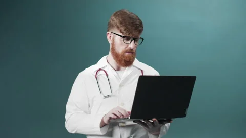A young red bearded doctor is taking a video consultation on the Internet with Stock Footage 170676514