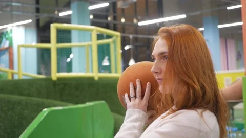 Young red-haired girl throws a basketball into a child's hoop Stock Footage 144267014