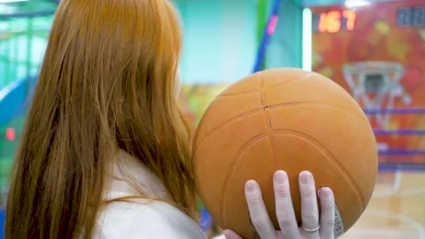 Young red-haired girl throws a basketball into a child's hoop Stock-Footage 144267031