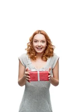 Young red-haired happy smiling girl holding gift Stock Photos