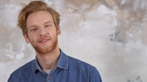 Young red-haired man isolated on painted wall impressed playful Stock Footage 121590310