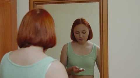 Young Red-Haired Woman Applying Facial Toner with Cotton Pad in Mirror Stock-Footage 344781832