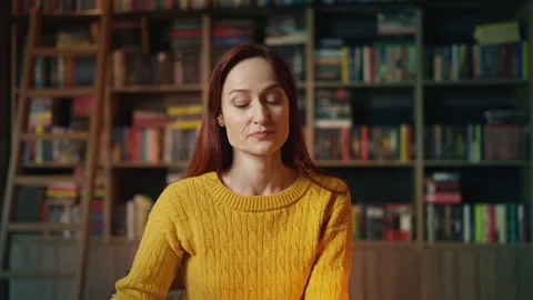Young red-haired woman checking phone after being stood up on library date Stock Footage 340267360