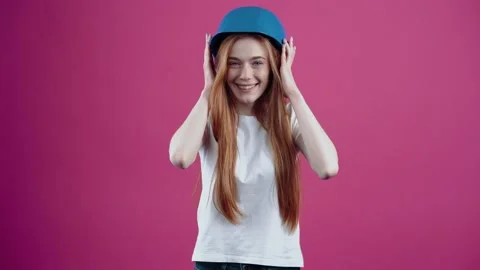 The young redhead with the blue helmet of an engineer smiles broadly, puts her Stock Footage 153978317