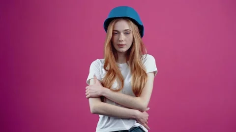 The young redhead engineer with the blue helmet puts both hands on her protector Video stock 153871924