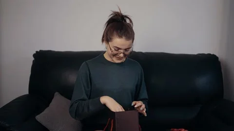 The young redhead, with glasses that opens the gift and surprised looks at its Stock Footage 163286287