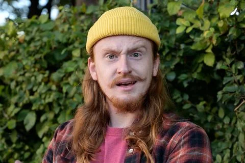 Young redhead guy expressing emotion of condemnation or disgust while looking Stock Photos