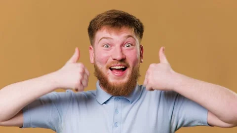 A young redhead guy gives a thumbs up with a Stock Footage 234690226