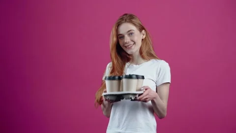 The young redhead, kind and optimistic offers a support with four coffees. The Stock Footage 154771252