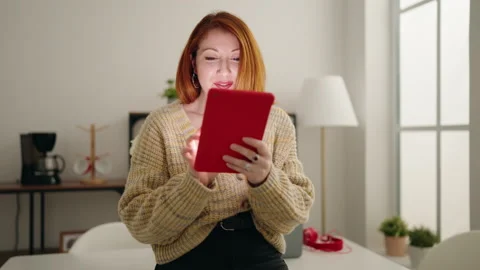 Young redhead woman using touchpad standing at home Stock Footage 172070335