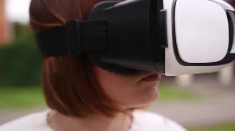 Young redhead woman using VR-helmet for smart phones. Augmented reality Stock Footage 66728293
