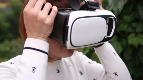 Young redhead woman using VR-helmet for smart phones. Augmented reality Stock Footage 66732206