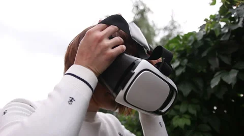 Young redhead woman using VR-helmet for smart phones. Augmented reality Stock Footage 66735339