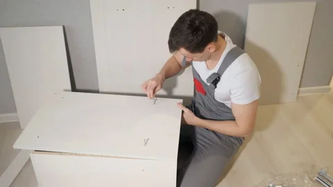 Young repairman assembling new table at home interior Stock Footage 99683427