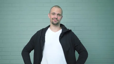 Young resourceful guy made a mask from the hood of his cardigan Stock Footage 134932307