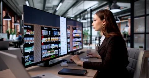 Young Retail Manager Uses Computer Software To Plan Supermarket Shelves. Stockfoto's