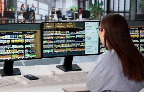 Young Retail Manager Uses Software On Computer To Optimize Product Placement. Stock Photos