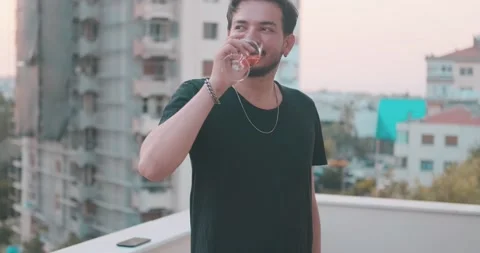 Young rich man is drinking red wine in rest time. Happy cheerful guy, party a Video stock 156492055