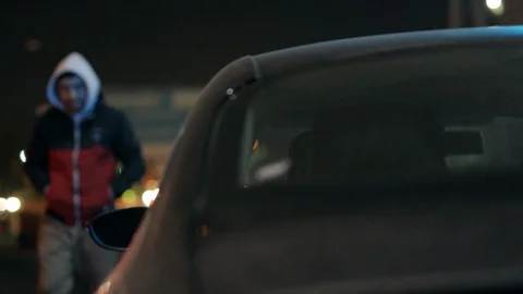 Young robber man checking shines a flashlight in a car stealing at night crime Vídeos de archivo 110888552