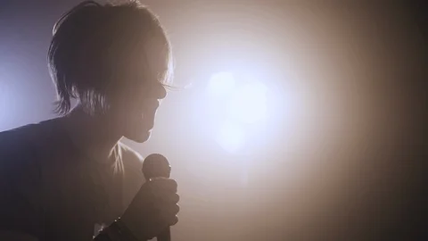 Young rockstar singing on stage with backlight Stock Footage 107783818