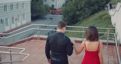 Young romantic couple descends down the stairs from the park Stock Footage 90828971