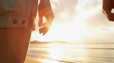Young romantic couple hold hands at sunset on shore in summer outdoor Vídeo Stock 64560320