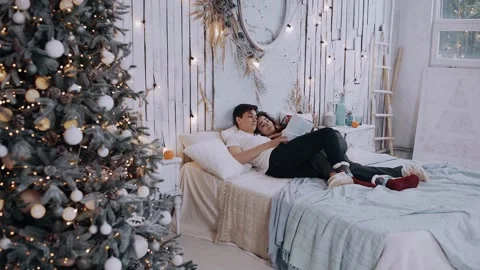 Young romantic couple lying on the bed with a gift in hand. Stock Footage 142746763
