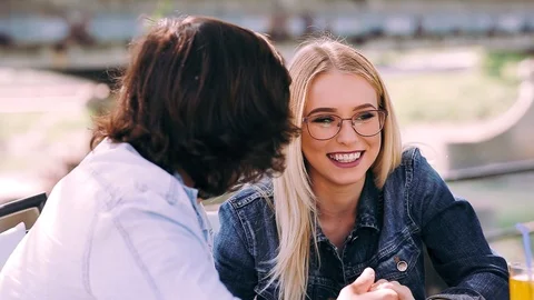 Young romantic couple spending time together - sitting in cafe's garden Stock Footage 89825245