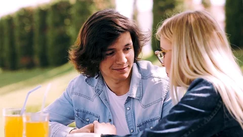 Young romantic couple spending time together - sitting in cafe's garden Stock Footage 89825514