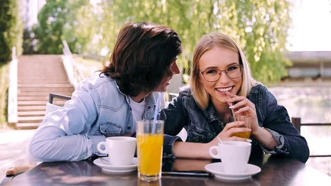 Young romantic couple spending time together sitting in cafe's garden Stock Footage 89825849
