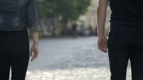 Young romantic couple taking hands and walking together outdoor in the city Stock Footage 78119471