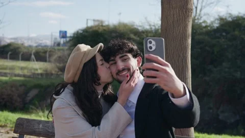 Young romantic couple taking a selfie in the park Stock Footage 325451809