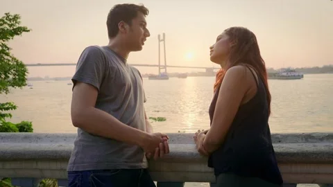 Young romantic date talking outdoors on waterfront during sunset in background. Stock Footage 268445422