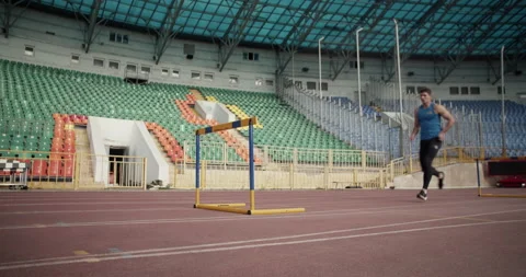 Young runner jumping over hurdle Stock Footage 199649064