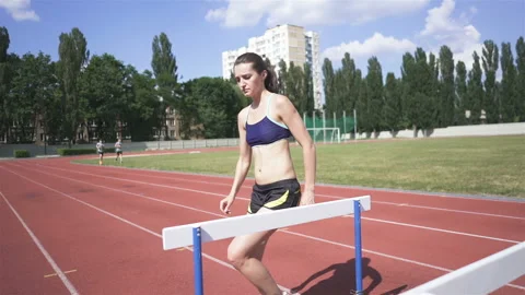 Young runner  on stadium training with barriers. Slow motion Video stock 119253972