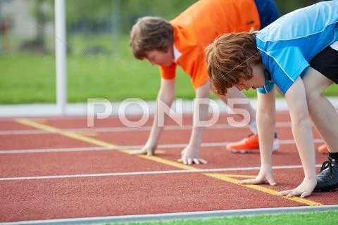 Young runners on starting position at racetrack Stock Photos