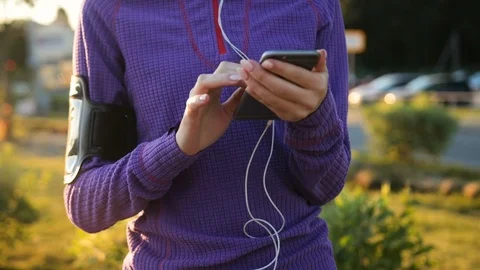 Young running beautiful girl is using smartphone application while resting Stock Footage 77194375