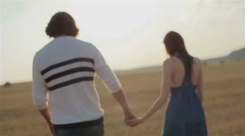 Young sad couple having troubles in relationship hand in hand walking in field Stock Footage 54638238