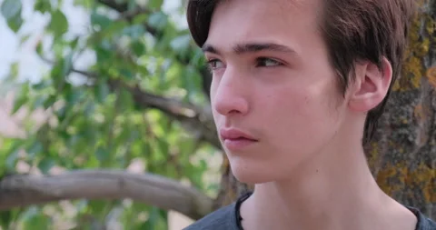 Young sad man is looking away. Unhappy alone young teenager, outdoors. Closeu Stock Footage 131044007