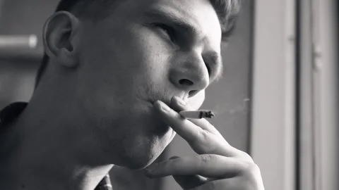 Young sad man smokes a cigarette. close-up. dramatic scene. Stock Footage 211812468
