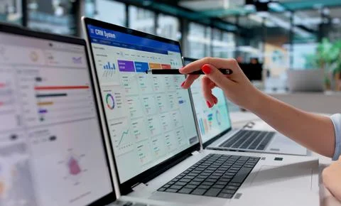 Young Sales Manager Analyzes Customer Data On Laptop To Improve Workflow. Stock Photos