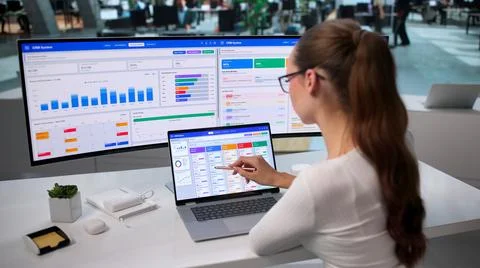 Young Sales Manager Studies Client Data On Laptop For Business Growth. Stock Photos