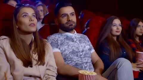 Young scared couple at the cinema watching an horror movie and screaming Stock Footage 75038440