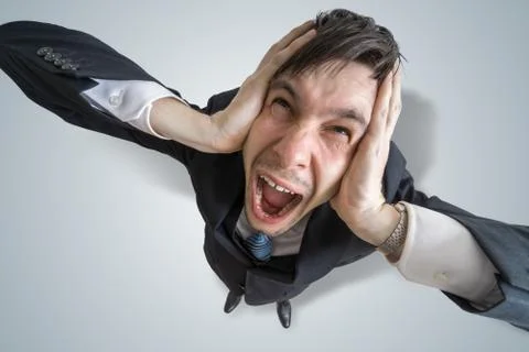 Young schizophrenic man suffers from headache and covering his ears with hands. Foto stock