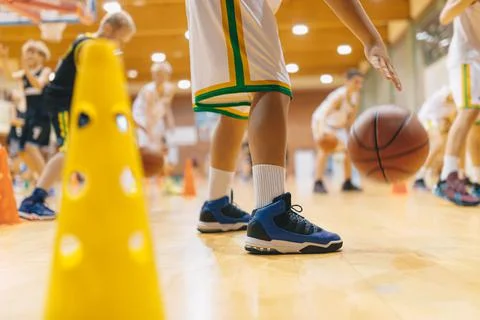 Young School Boys Practicing Bouncing Basketballs on School Wooden Court Stock Photos