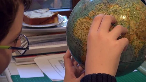Young school student studying for geography with a globe Stock Footage 71962488